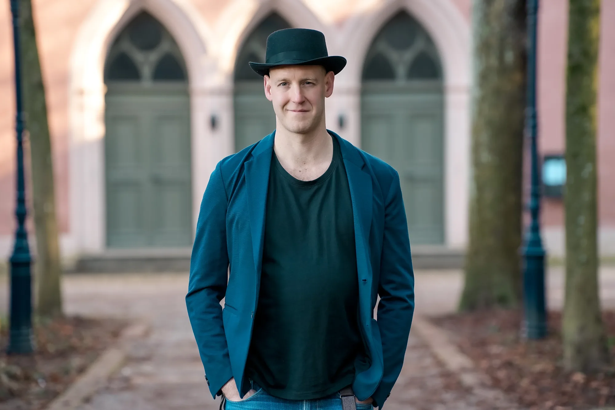 Michael Peter portrait wearing a black hat and blue jacket